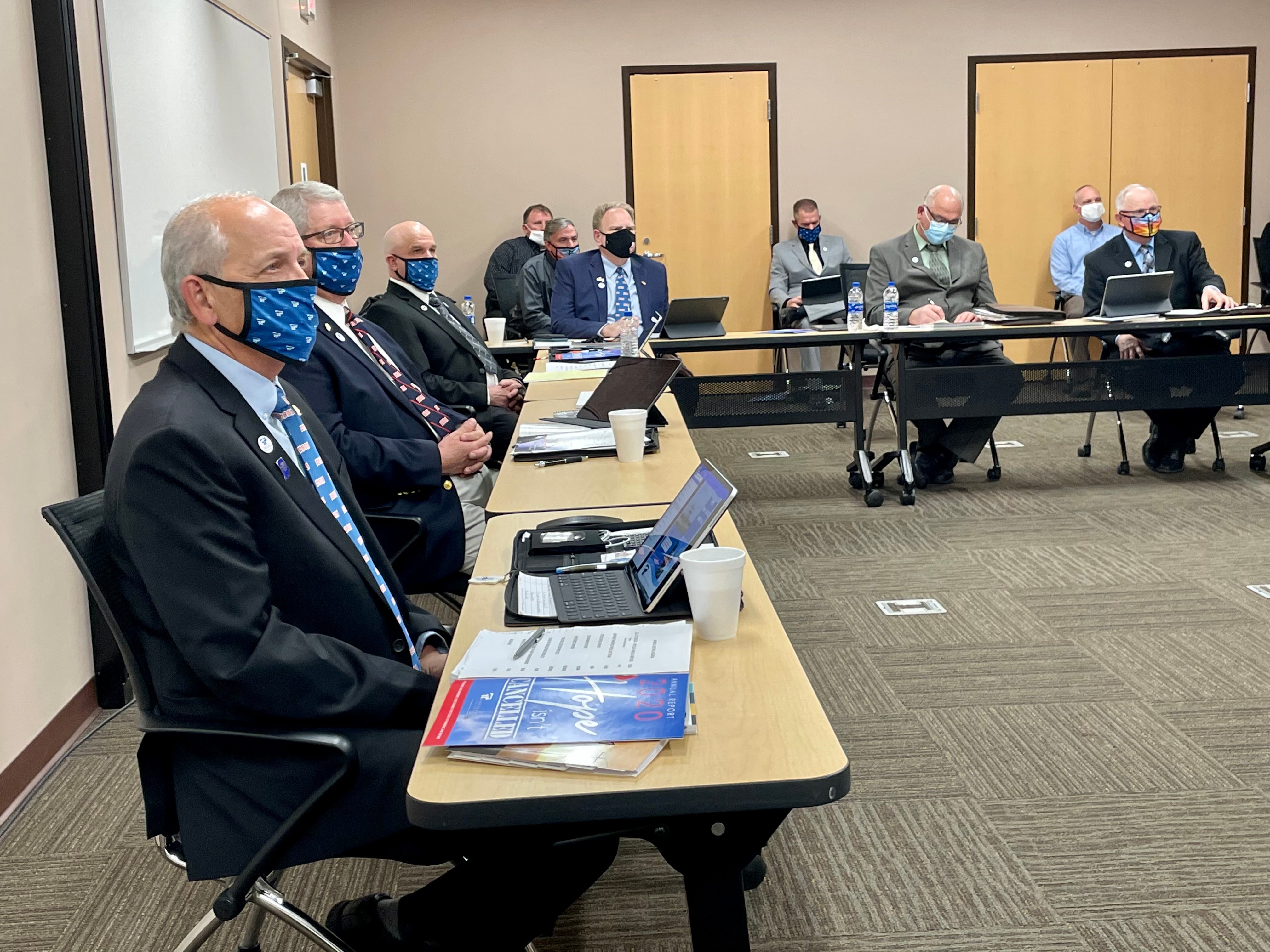 board sits to listen to meeting