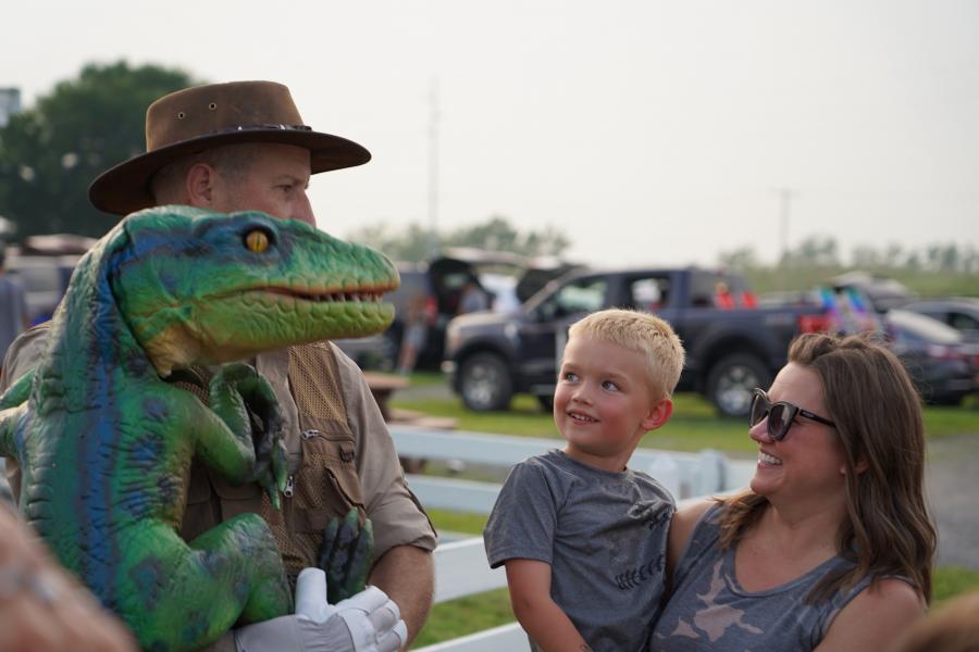 little boy smiling at dinosaur.JPG